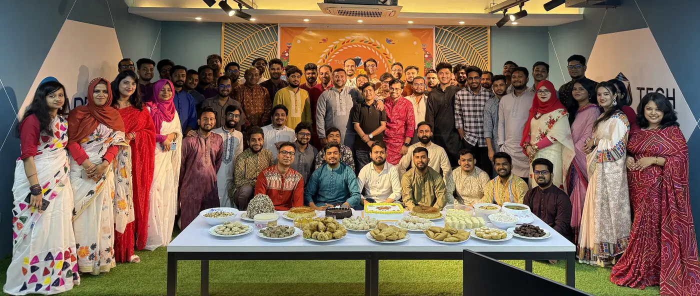 The TulipTech Bangladesh team gathered around a table of food at a celebration