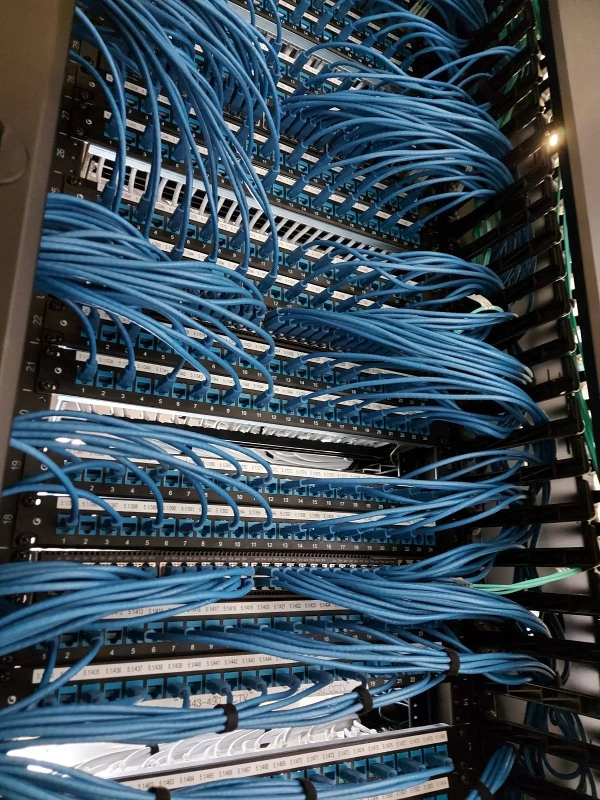 Racked patch panels and blue structured cabling at the TTEC Leeds build